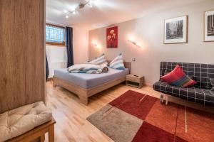 ein Schlafzimmer mit einem Bett und einer Couch in der Unterkunft Wieseneck ii - Apartment in Fügen in Fügen