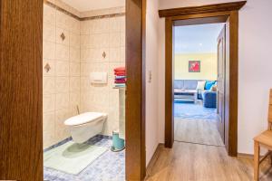 ein Badezimmer mit WC und ein Wohnzimmer in der Unterkunft Wieseneck ii - Apartment in Fügen in Fügen