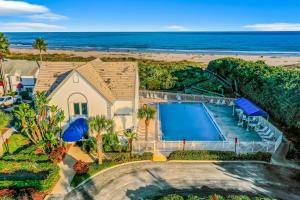 an aerial view of a house with a swimming pool and the beach at Sandy Nose in Cape Canaveral