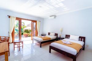 a hotel room with two beds and a balcony at D'Canggu Homestay in Canggu