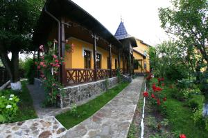 una casa con flores a un lado. en Pensiunea Elena, en Târgu Ocna