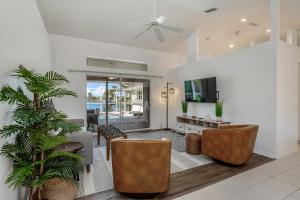 a living room with a couch and chairs and a tv at Hook, Line, and Sunsets in Port Charlotte