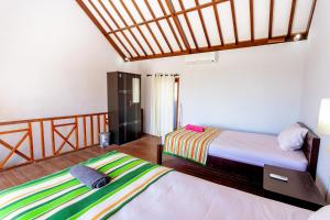 a bedroom with two beds and a wooden floor at D'Canggu Homestay in Canggu