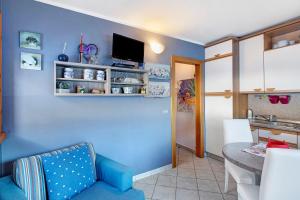 a kitchen and dining room with a blue wall at Baita del Sole Appartamento 1 in Livigno