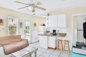 a living room with a couch and a kitchen at Seaside Sweetheart in Clearwater Beach