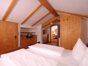 a bedroom with a bed with white sheets at Ferienhaus Martlerhof in Tux