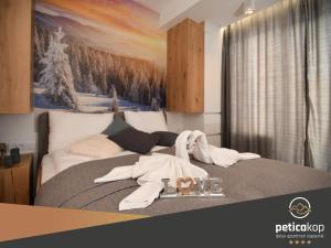 1 dormitorio con 1 cama con toallas en Apartman PETICA KOP A8 Kopaonik en Kopaonik