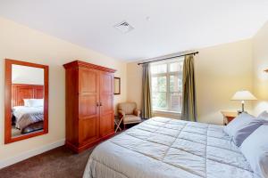 斯特拉頓的住宿－Founders Lodge 209，一间卧室配有一张床和镜子