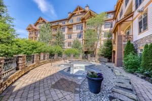 un gran edificio de apartamentos con una pasarela de piedra en la parte delantera en Founders Lodge 209 en Stratton