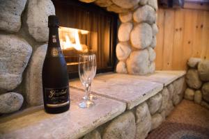 a bottle of wine and a wine glass on a stone wall at Cathy's Cottages in Big Bear Lake