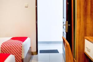 a room with a bed and a table and a door at Hotel O Papakoel in Medan