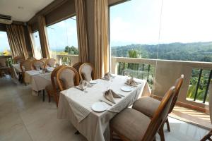 a restaurant with tables and chairs and a large window at The Delight Residence in Kandy