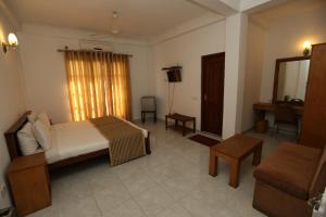 a bedroom with a bed and a couch and a table at The Delight Residence in Kandy