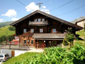 a wooden house on a hill with a car parked in front at Ferienhaus Martlerhof in Tux