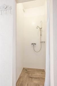uma casa de banho com um chuveiro numa parede branca em Apartment Ferienwohnung em Pula