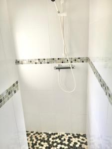 ein Bad mit einer Dusche und einem karierten Boden in der Unterkunft Studios meublés Brest Keruscun in Brest