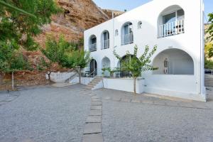 a white building with trees in front of it at Ilingas Mare in Khóra Sfakíon