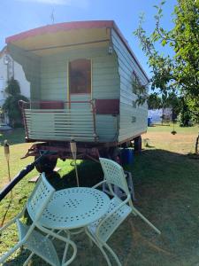 une petite maison sur une remorque avec deux chaises dans l'établissement Relais des Chaux, à Saint-Jean-des-Ollières