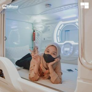 a baby in a hospital room wearing a mask at TABHotel Capsule Bandung in Bandung