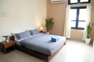 a bedroom with a bed with blue pillows and a window at JOY'S BNB in Imphal