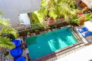an overhead view of a swimming pool with palm trees at D'Canggu Homestay in Canggu +45 photos
