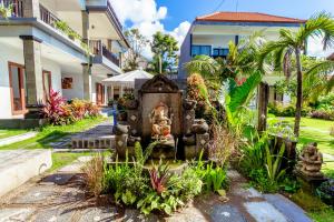 a garden with a statue in front of a building at D'Canggu Homestay in Canggu