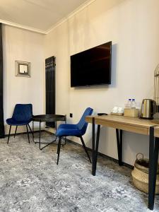 Habitación con 2 sillas, mesa y TV. en Altrimo Hotel, en Rybachi