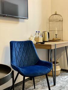 einem blauen Stuhl neben einem Schreibtisch mit Vogelkäfig in der Unterkunft Altrimo Hotel in Rybatschi