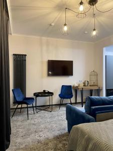 een woonkamer met een bank en stoelen en een tv bij Altrimo Hotel in Ribatsjiy
