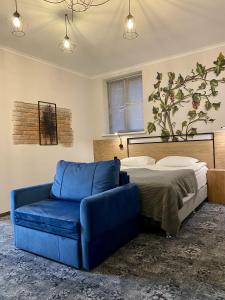 1 dormitorio con sofá azul y cama en Altrimo Hotel en Rybachiy