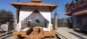 a gazebo on the deck of a house at Mehra Cottage in Almora