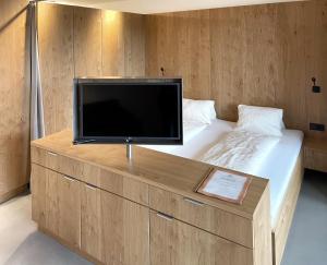 einen Flachbild-TV auf einem Bett in der Unterkunft Apartmenthaus Anna in Lustenau