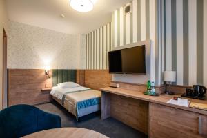 a hotel room with a bed and a flat screen tv at Hotel La Mar in Kielce