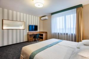 a hotel room with a bed and a desk and a television at Hotel La Mar in Kielce