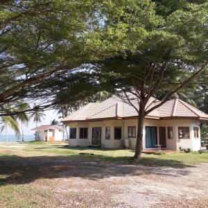ein Haus mit einem Baum davor in der Unterkunft Baan Be Beach in Lang Suan