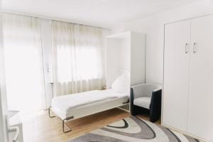 um quarto branco com uma cadeira e um espelho em Apartment-EG-05 em Darmstadt