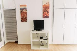 uma televisão numa mesa branca num quarto em Apartment-EG-05 em Darmstadt
