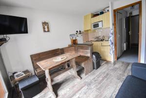 a kitchen with a wooden table in a room at Au Pied des Pistes B48, Chaleureux studio 4 pers, balcon plein SUD, DRAPS NON COMPRIS in Saint-Jean-dʼAulps +13 photos