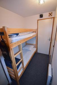 a bunk bed in a small room with a bunk bedscribed at Au Pied des Pistes B48, Chaleureux studio 4 pers, balcon plein SUD, DRAPS NON COMPRIS in Saint-Jean-dʼAulps
