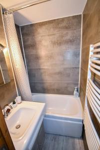 a bathroom with a white tub and a sink at Au Pied des Pistes B48, Chaleureux studio 4 pers, balcon plein SUD, DRAPS NON COMPRIS in Saint-Jean-dʼAulps