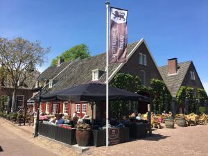 een groep mensen in een restaurant onder een paraplu bij Herberg de Gouden Leeuw in Bronkhorst