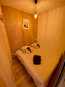 een klein bed in een kleine kamer met een spiegel bij N°2 L'épicéa - Appart Hôtel La Maison Sévigné in Béthune +12 foto's