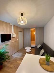 een woonkamer met een tafel en een bank bij N°2 L'épicéa - Appart Hôtel La Maison Sévigné in Béthune