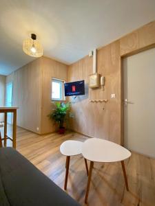 een woonkamer met een witte tafel en een tv bij N°2 L'épicéa - Appart Hôtel La Maison Sévigné in Béthune