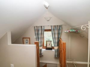 a attic room with a staircase and a window at Charlottes Cottage in Bamford