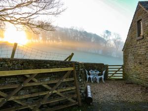 a fence with a gate and a bench next to a wall at Charlottes Cottage in Bamford +11 photos