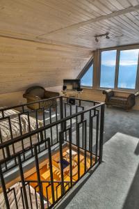 a room with a bed and chairs and windows at Top House in Yaremche