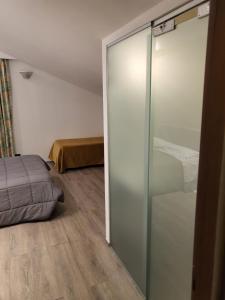 um quarto com uma porta de vidro que leva a uma cama em Hotel Miage em Aosta