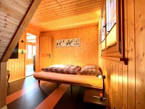 a bedroom with a bed in a wooden room at Top location near Rapperswil 