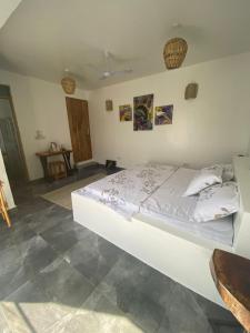 a bedroom with a large white bed in a room at Peanut and Butter Guesthouse and Bistro in Nungwi